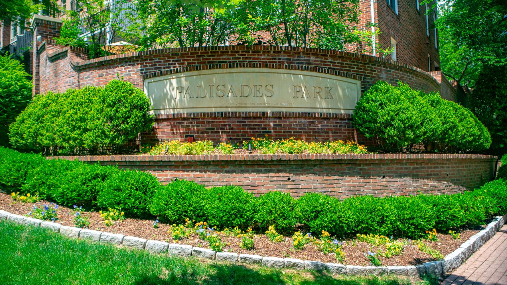 HOA entrance sign with bushes and flowers