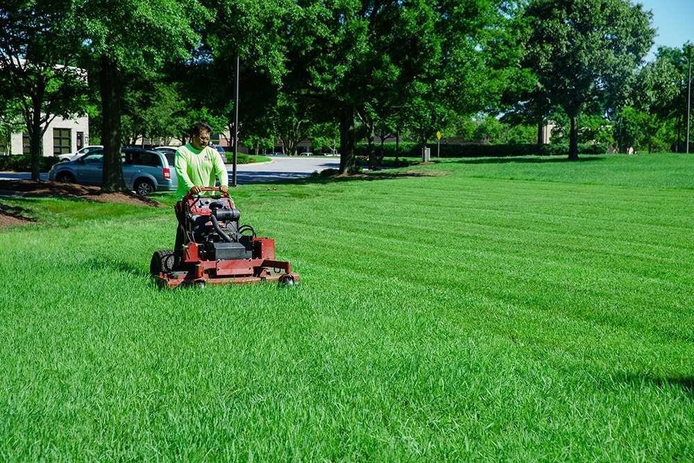 Lawn care technician mowing lawn