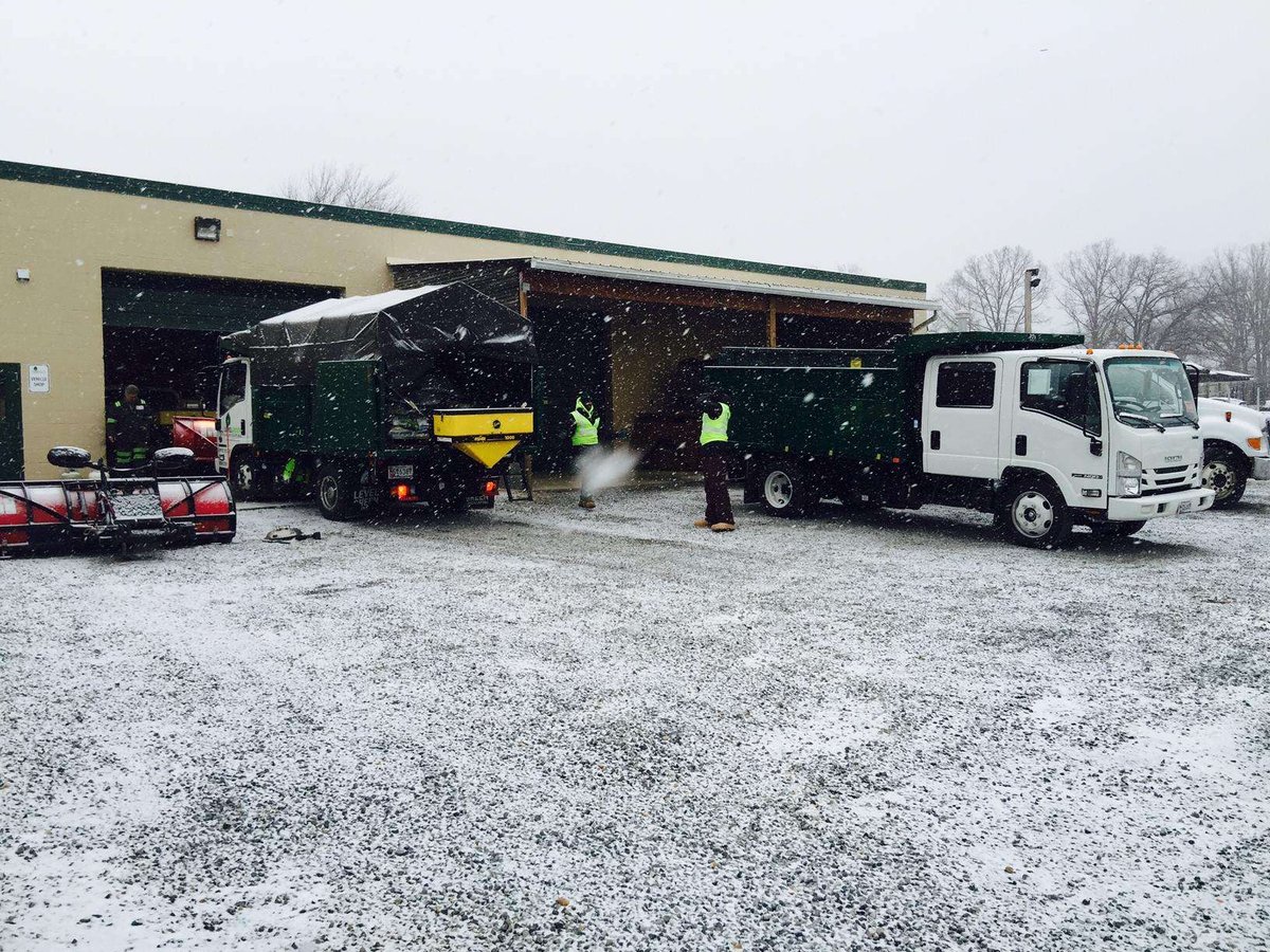 snow removal team meets outside building with trucks