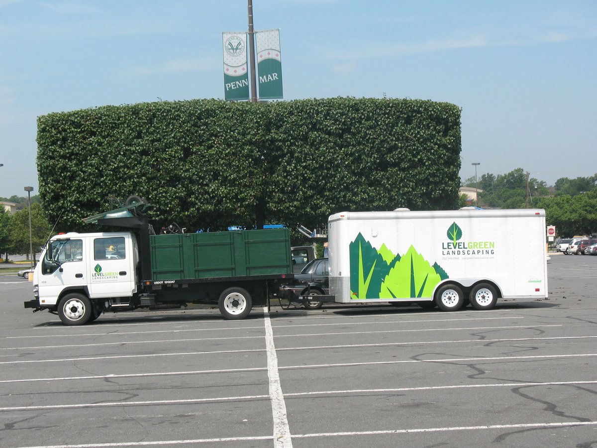Level Green truck and trailer parked in commercial parking lot