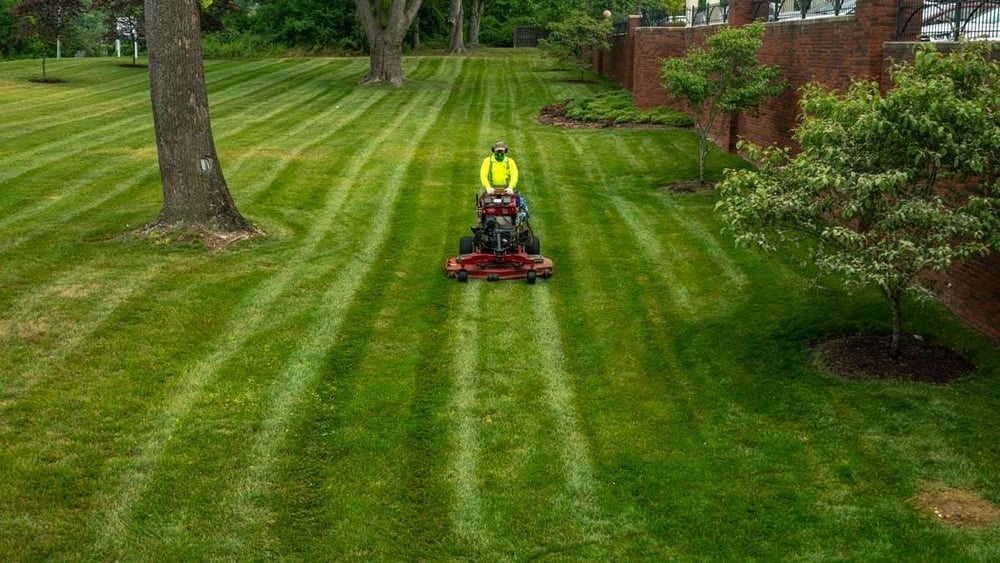 commercial landscaper mowing lawn