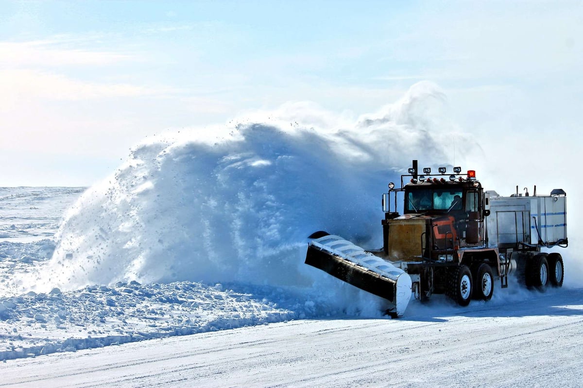 truck plows snow on roadway