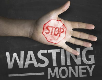 "stop wasting money" text on blackboard