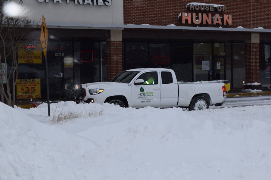 truck plows snow at commercial property
